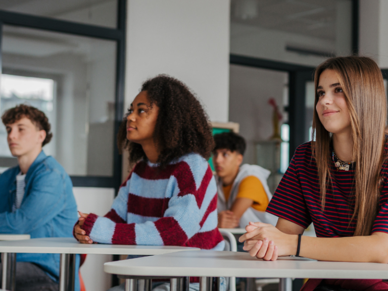 Drie leerlingen doen actief mee tijdens een les over controversiële kwesties in de klas.